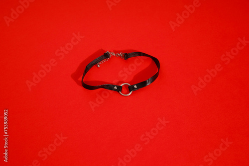 Leather choker jewellery with metallic details & red colour background photo