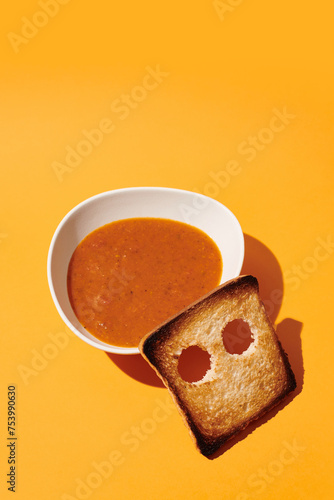 a bowl of tomato soup with a piece of bread in the shape of a ghost photo