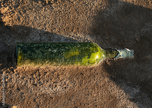 Botella de vidrio enterrada en la playa