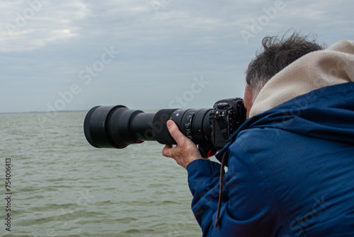 Fotógrafo en acción en el mar con un teleobjetivo