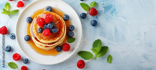 Owl shaped pancakes with berries, honey on white plate, kids breakfast concept on bright background
