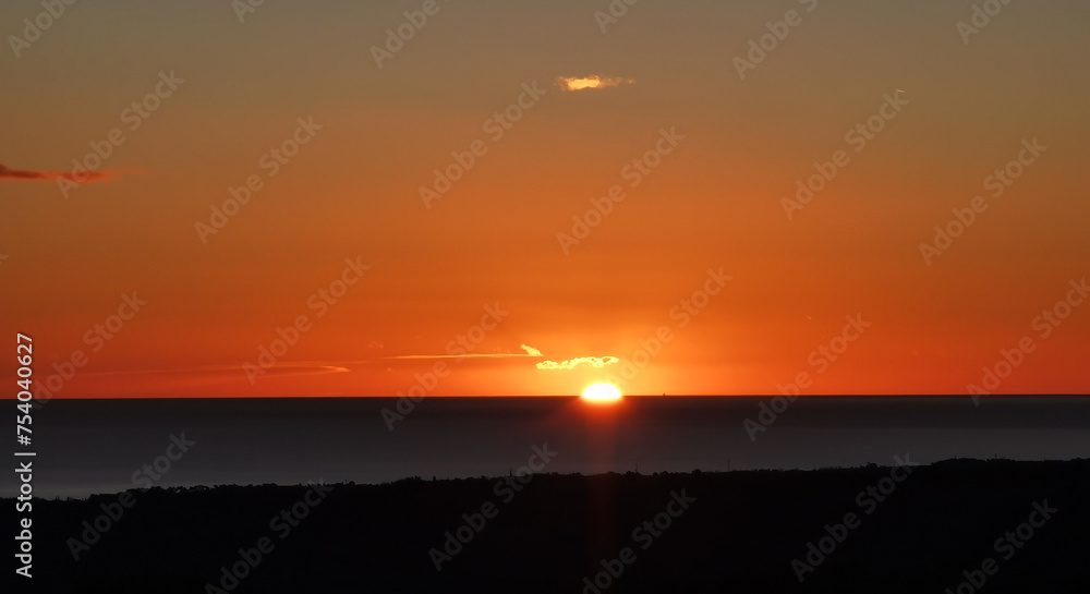 Il Sole accecante che all’alba sorge dal mare visto da sopra le colline Il Sole accecante che all’alba sorge dal mare visto da sopra le colline