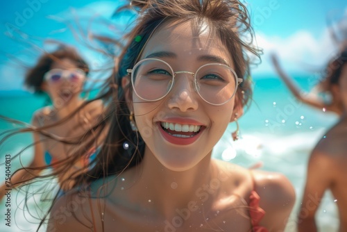 Happy Young Women Enjoying Summer Vacation on Tropical Beach with Blue Sky and Clear Sea