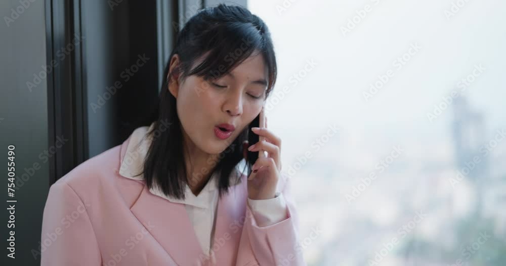 Focused businesswoman converses on her phone against the backdrop of a sprawling urban cityscape. Focused businesswoman converses on her phone against the backdrop of a sprawling urban cityscape.