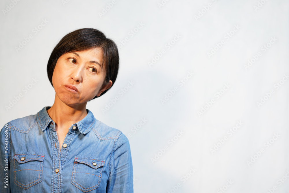 真顔で首を傾ける中年女性 真顔で首を傾ける中年女性