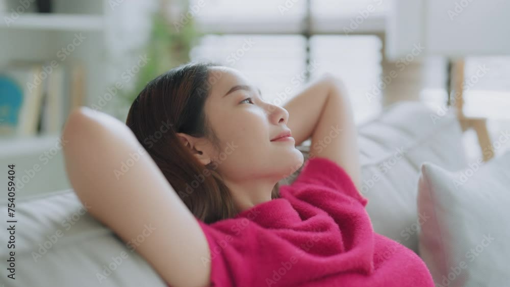 Relaxed young Asian woman enjoying rest on comfortable sofa, calm attractive girl relaxing on couch, breathing fresh air with eyes closed, meditating at home Relaxed young Asian woman enjoying rest on comfortable sofa, calm attractive girl relaxing on couch, breathing fresh air with eyes closed, meditating at home