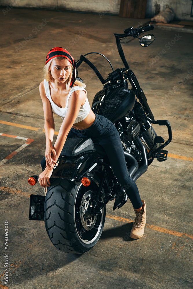 Obraz premium Fashion shooting with white young female posting on big motorcycle.