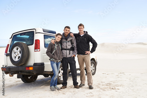 Friends, portrait and people with car in desert, travel and tourism in Dubai for safari and road trip. Adventure, journey and transportation, offroad vehicle or 4x4 on vacation with break outdoor