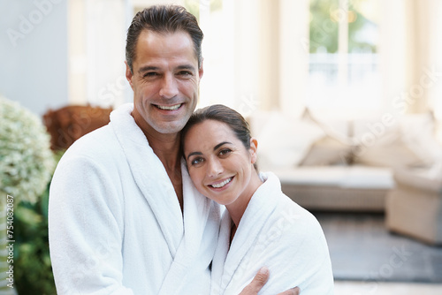 Portrait, robe and couple at hotel with embrace, smile and relax together at wellness spa holiday. Hospitality, happy woman and man hug at luxury villa for travel, vacation and love on romantic date © Katie/peopleimages.com