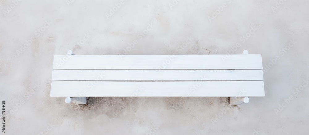 A white bench rests atop a sturdy cement wall, creating a stark contrast between the peaceful background. The bench is positioned in the center, offering a unique perspective of urban architecture. A white bench rests atop a sturdy cement wall, creating a stark contrast between the peaceful background. The bench is positioned in the center, offering a unique perspective of urban architecture.
