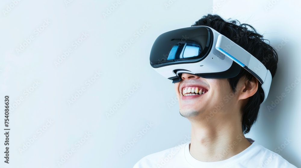 Smiling man on a white background while looking through a VR headset and making expressive gestures Smiling man on a white background while looking through a VR headset and making expressive gestures