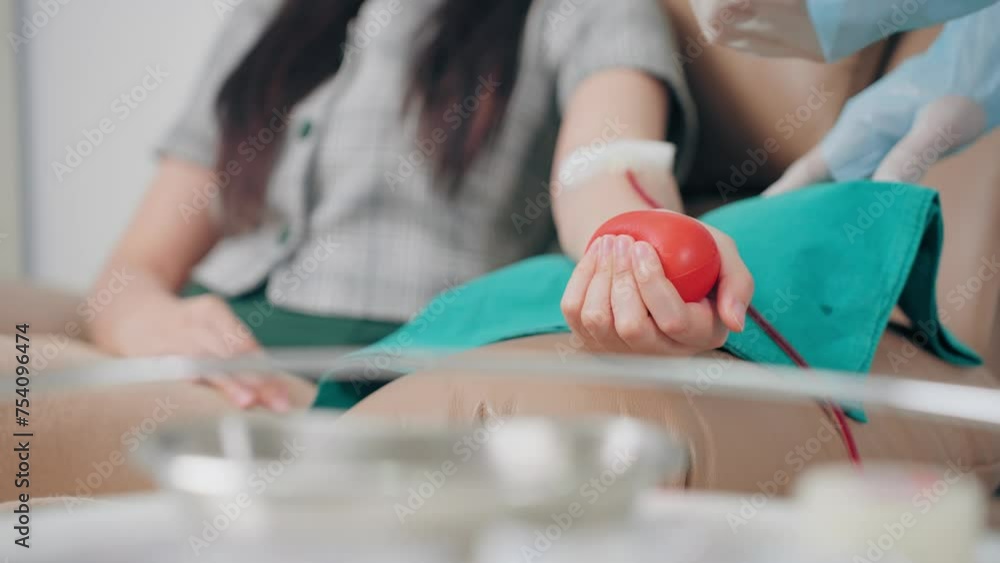 Blood donor handful rubber heart in hand during donation at hospital. Blood donate volunteer charity concept Blood donor handful rubber heart in hand during donation at hospital. Blood donate volunteer charity concept
