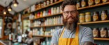 Man With Beard and Glasses Standing in Front of Shelves of Beer