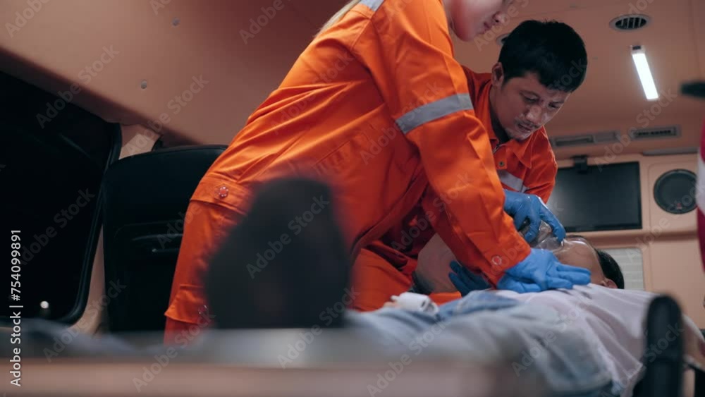 Asian woman emergency medical technician (EMT) or paramedic nurse is performing CPR on a patient in an ambulance car Asian woman emergency medical technician (EMT) or paramedic nurse is performing CPR on a patient in an ambulance car