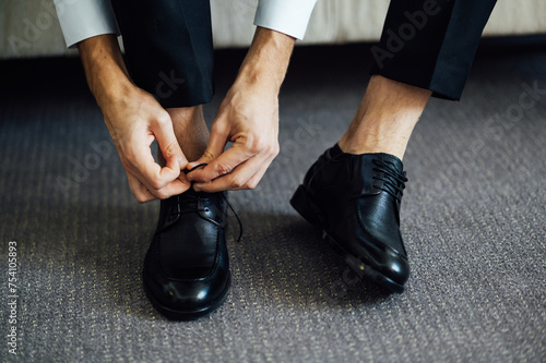 Man ties his black shoes. Close-up view