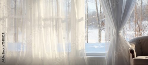 A wooden chair is placed in front of a window covered in white curtains, creating a simple yet elegant scene in a sunlit room during winter.