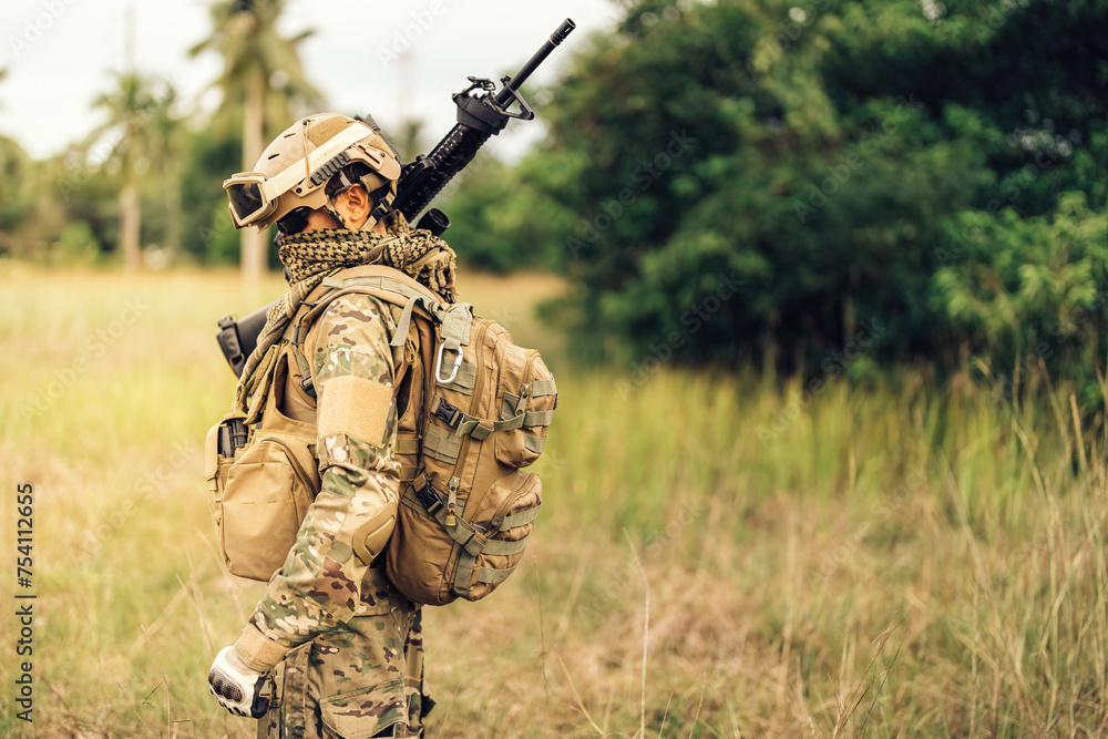 Fototapeta premium Special forces soldiers receiving orders from the Pentagon carry rifles and prepare to patrol in the forest, wearing camouflage uniforms, goggles, and helmets. to plan an attack on the enemy