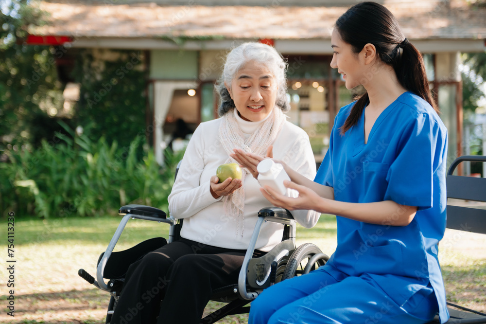 Elderly asian senior woman on wheelchair with Asian careful caregiver. Nursing home hospital Elderly asian senior woman on wheelchair with Asian careful caregiver. Nursing home hospital