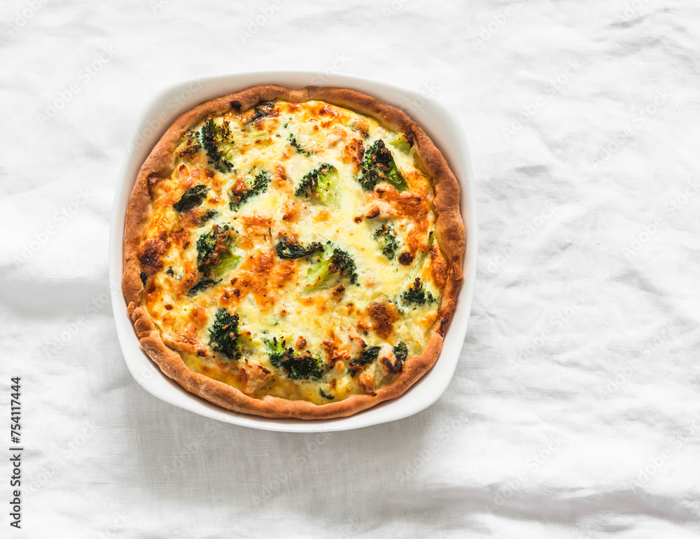 Quiche with broccoli, chicken, spinach and cheese on a light background, top view Quiche with broccoli, chicken, spinach and cheese on a light background, top view
