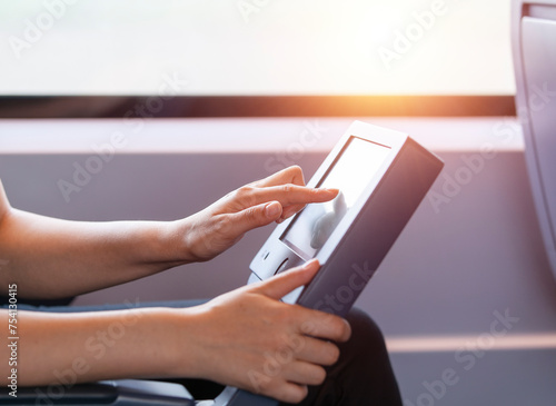 Female hand touching the screen of train information system located by the seat on the speed train during travel. Passenger getting information about the travel.