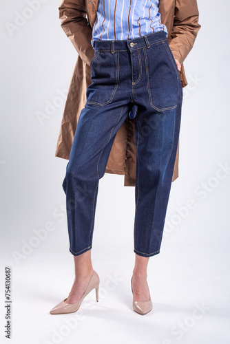 Fashion model posing in stylish blue jeans with brown trench coat photo