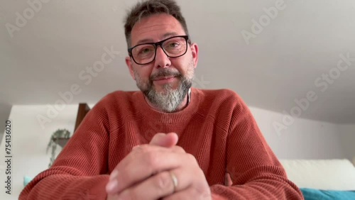 Mature older man virtual psychologist teacher consulting patient teaching student looking talking to camera make conference call recording video training sit on sofa at home office, webcam view