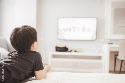 Little boy watching television at home. Copy space. Soft focus.