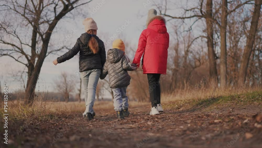 children walk in the forest in autumn park. happy family kid dream concept. a group of children holding hands in jackets in the fall walking in a park in the forest. freedom childhood nature concept children walk in the forest in autumn park. happy family kid dream concept. a group of children holding hands in jackets in the fall walking in a park in the forest. freedom childhood nature concept