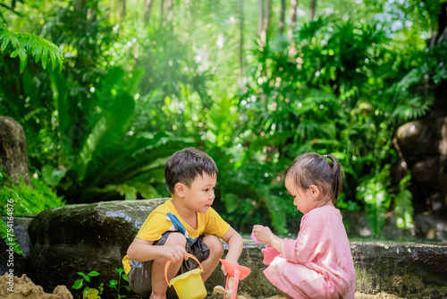 Asian child boy and girl playing toys and sand with natural background. Fine motor skills development for little child. Soft focus. Copy space.