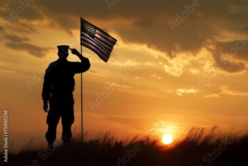 Silhouette of a military person saluting the American flag at sunset. photo