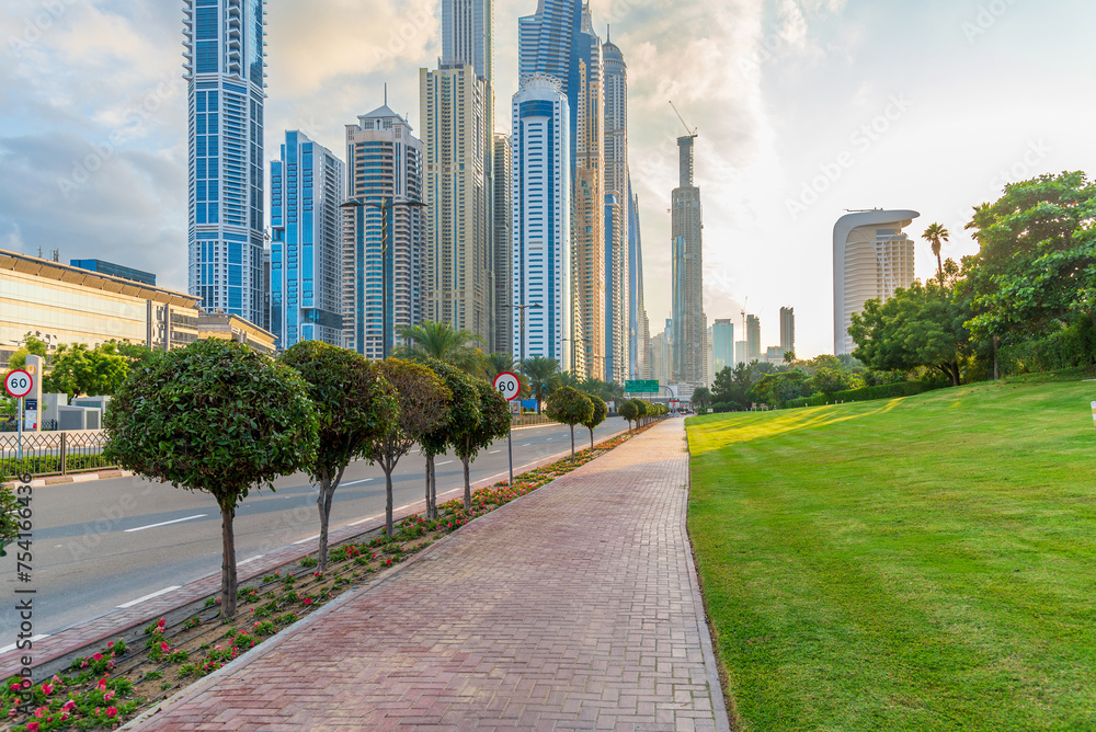 Sunset in the Dubai Marina area. View of skyscrapers from the sidewalk