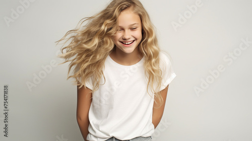 Smiling teenage girl in a white T-shirt on a white background mockup. Childhood lifestyle concept. Mockup copy space. Scandinavian girl model