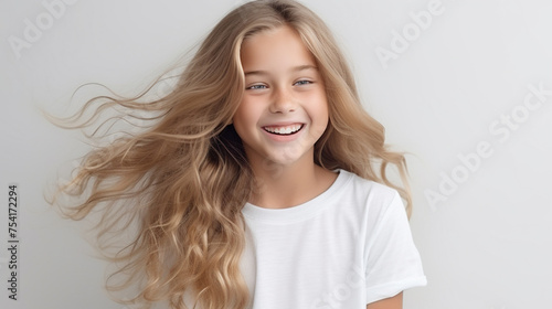 Smiling teenage girl in a white T-shirt on a white background mockup. Childhood lifestyle concept. Mockup copy space. Scandinavian girl model © EltaMax99