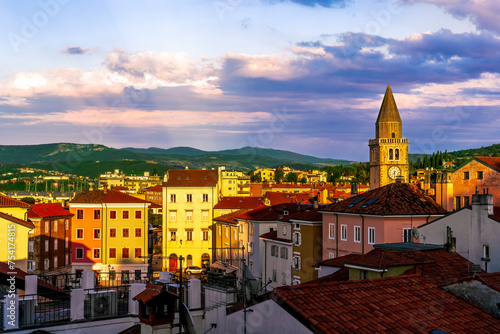 amazing evening town with church, tower with bell , yellow houses and beautiful hills with nice cloudy sky on background, european cityscape of Italy