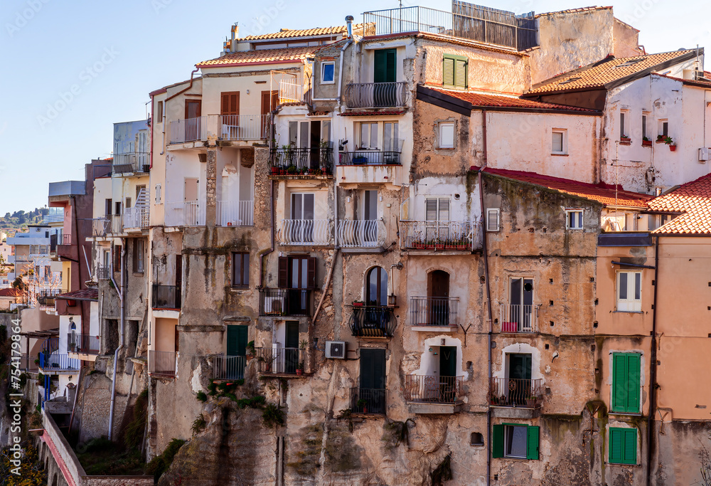scenic travel landscape of beautiful historic town Tropea in Italy with old antique buildings, vintage houses on a high rock cliff above sea and amazing blue sky on background