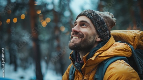 Handsome man smiling and relaxing with winter nature while camping.