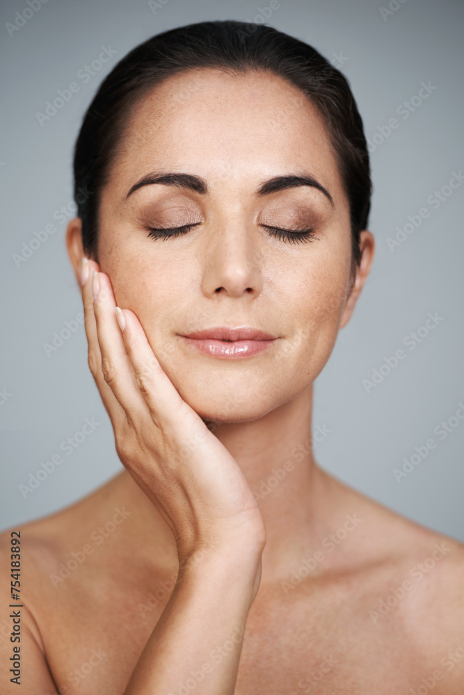 Beauty, mature and skincare of woman touching face with makeup at studio isolated on gray background. Cosmetics, glow and hand of model in facial treatment for dermatology, anti aging and eyes closed Beauty, mature and skincare of woman touching face with makeup at studio isolated on gray background. Cosmetics, glow and hand of model in facial treatment for dermatology, anti aging and eyes closed