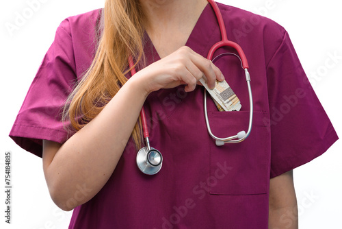 Kobieta lekarz wkłada pieniądze do kieszeni kitla