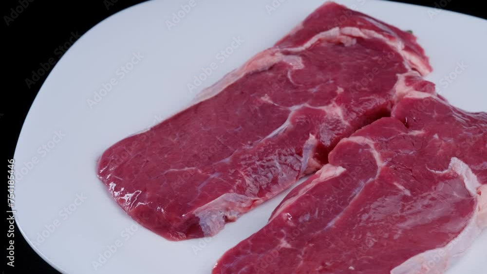 Raw beef steak spinning close-up Raw beef steak spinning close-up