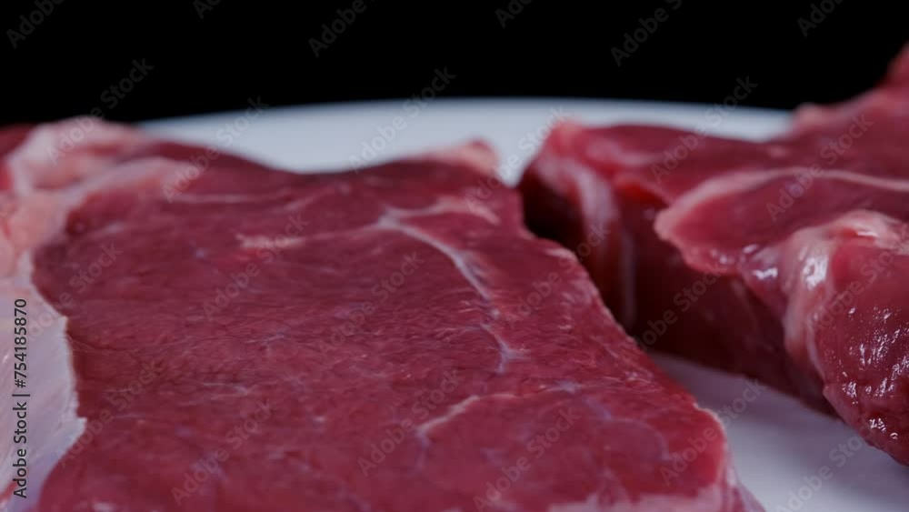 Raw beef steak spinning close-up Raw beef steak spinning close-up