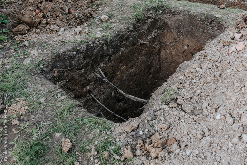 A hole dug to fix a water pipe leak. A carefully dug hole without damaging the high-voltage cable. Repair and restoration works.