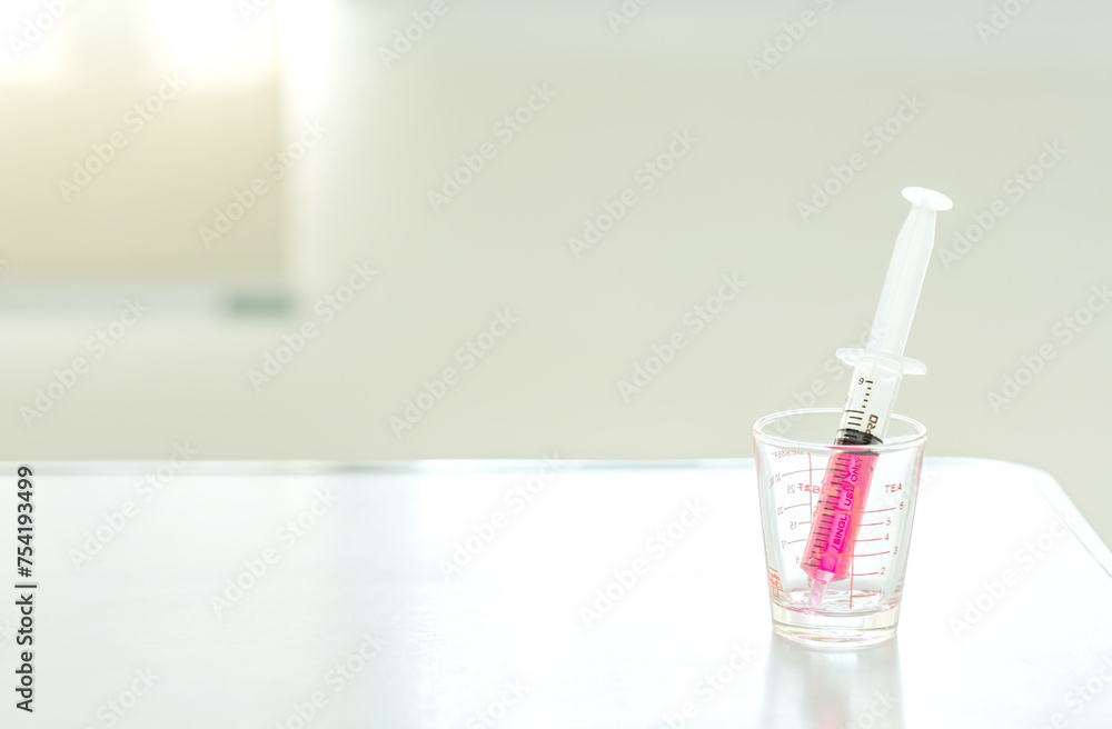 Sweet red drug or water medicine by syringe pump on desk at hospital room. Health and medical concept. Soft focus. Copy space. Sweet red drug or water medicine by syringe pump on desk at hospital room. Health and medical concept. Soft focus. Copy space.
