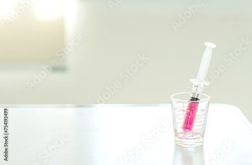 Sweet red drug or water medicine by syringe pump on desk at hospital room. Health and medical concept. Soft focus. Copy space. 