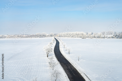 Empty road leading through a snowy winter landscape