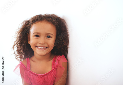 Girl, kid and portrait or smile in home with confidence, wellness and trendy outfit for fashion aesthetic. Child, face and happy with relax by wall in living room with mockup, good mood or curly hair