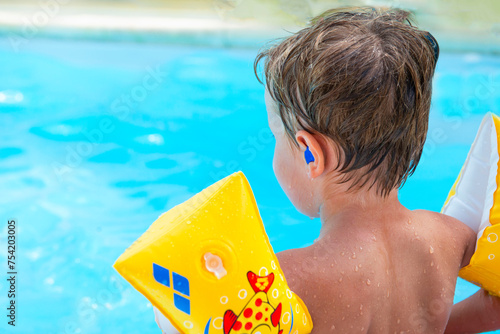 Canvastavla enfant avec des bouchons d'oreille à la piscine, prévention otite