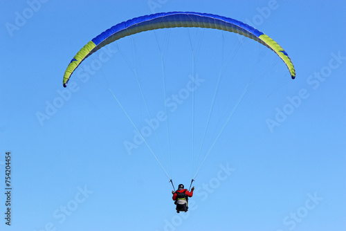 Paraglider flying in a blue sky 