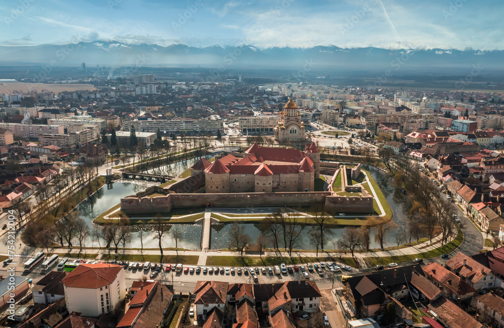 Aerial view with Fagaras Citadel Fortress, the Cathedral and the mountains in Romania