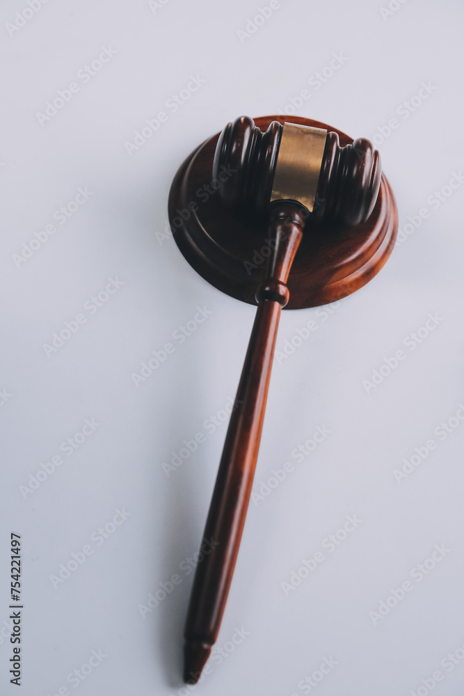 Justice and Law concept. Legal counsel presents to the client a signed contract with gavel and legal law or legal having team meeting at law firm in background Justice and Law concept. Legal counsel presents to the client a signed contract with gavel and legal law or legal having team meeting at law firm in background