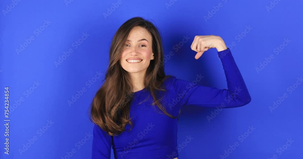 Feminism and women power. Do it! Self assured proud woman brags about her strength raises arm and shows muscles in hands. Girl show her power and look proud. I am strong and independent stand on blue. Feminism and women power. Do it! Self assured proud woman brags about her strength raises arm and shows muscles in hands. Girl show her power and look proud. I am strong and independent stand on blue.